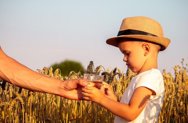 Padre e hijo con un vaso de agua Enfoque selectivo Niño