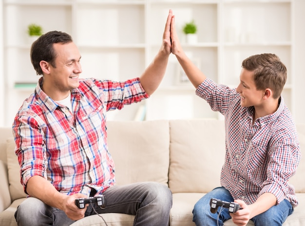 Padre e hijo vestidos casuales divirtiéndose en casa.