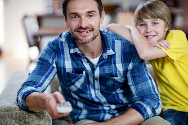 Padre e hijo viendo televisión en la sala de estar