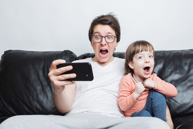 Padre e hijo viendo un video de miedo en el teléfono