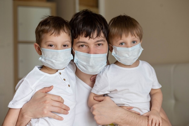 Padre e hijos con máscaras médicas en casa. Imagen con enfoque selectivo. Foto de alta calidad