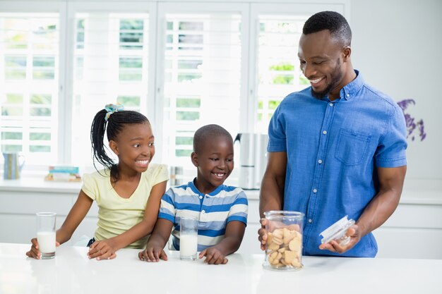 Padre e hijos mirando las galletas en la mesa