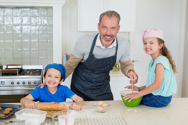 Padre e hijos preparando comida en la cocina