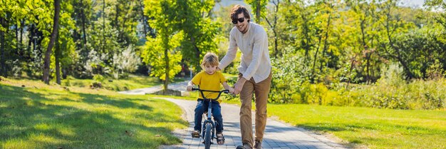 Padre enseña a su hijo a andar en bicicleta banner formato largo