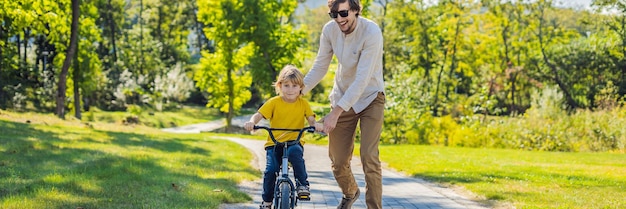 Padre enseña a su hijo a andar en bicicleta banner formato largo