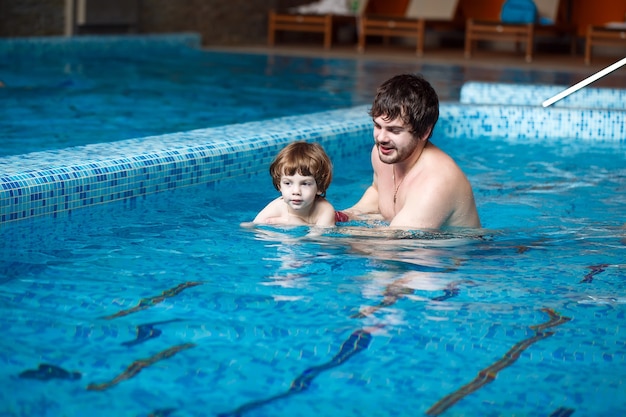Padre enseña a su hijo a nadar en la piscina.