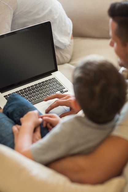 Padre enseñando a niño a usar la computadora portátil