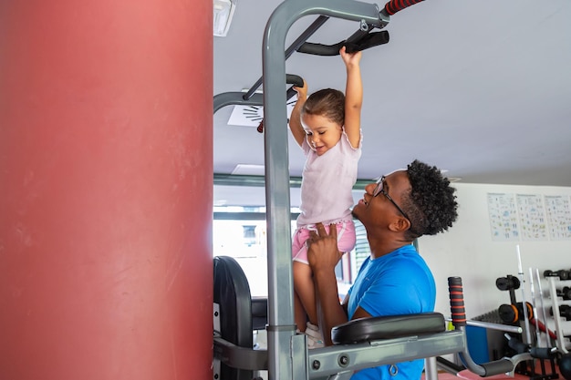 Foto padre enseñando a su hija a hacer flexiones