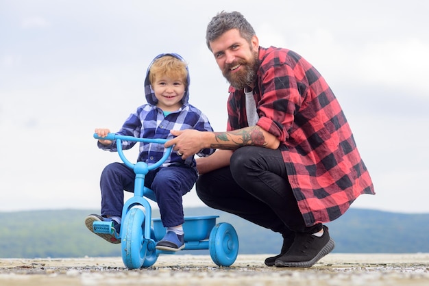 Foto padre enseñando a su hijo a andar en bicicleta niño aprende a andar en bicicleta con su papá papá t
