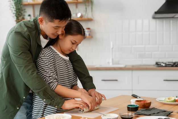 Padre enseñando a su hijo a hacer sushi