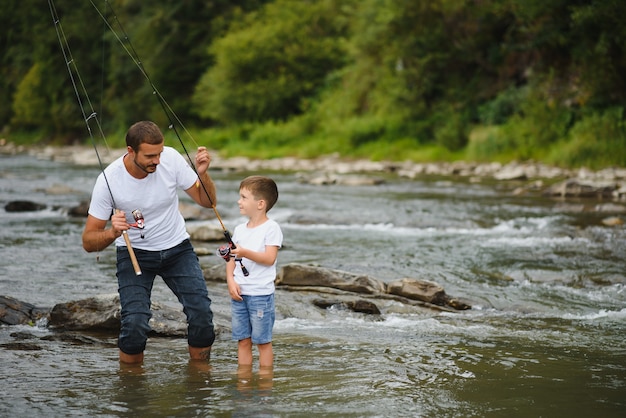 Padre enseñando a su hijo a pescar en el río.