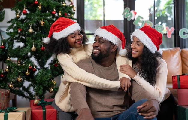 Padre de familia afroamericano, madre e hija felices celebran las vacaciones de Navidad en casa