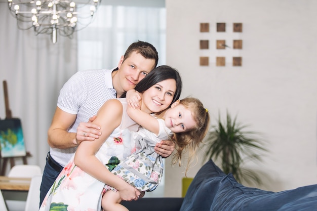 Padre de familia, madre, hija juntos hermosos y felices en casa juntos