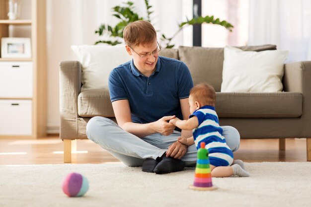 Foto padre feliz con el bebé hijo en casa