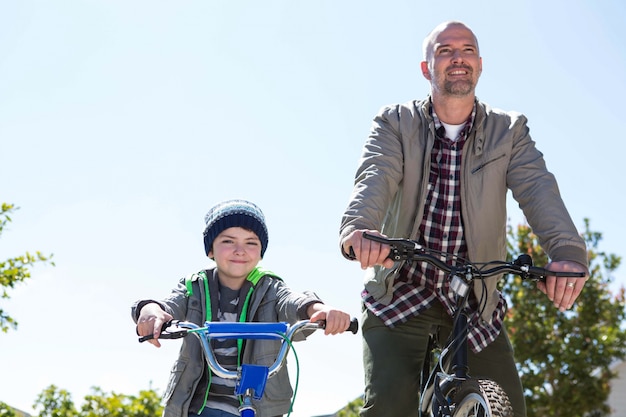 Padre feliz en una bicicleta con su hijo