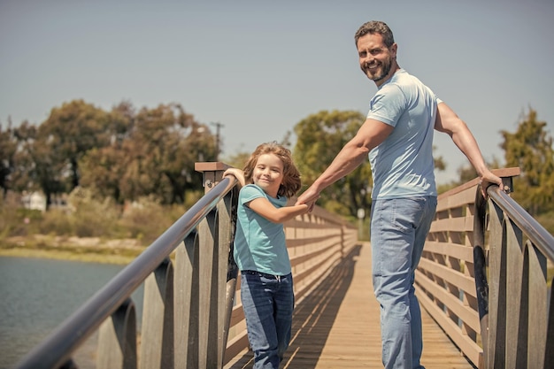 Padre feliz divirtiéndose con su hijo caminando al aire libre en verano