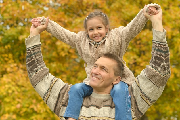 Padre feliz con hija en el parque otoño