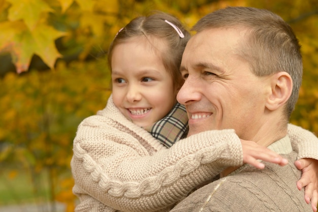 Padre feliz con hija en el parque otoño