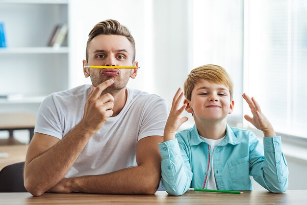 El padre feliz y un hijo jugando en el escritorio.