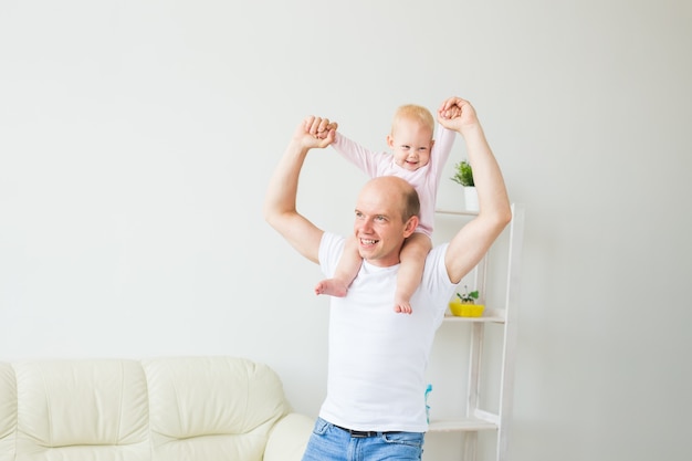 Padre feliz jugando con la pequeña niña en casa