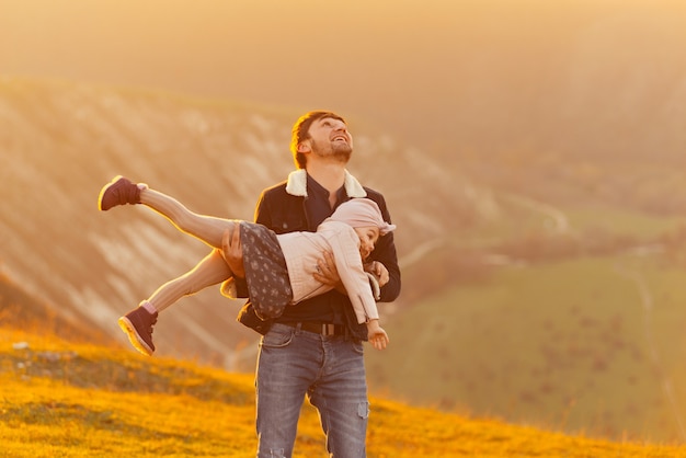 Padre feliz jugando con su hija en la naturaleza