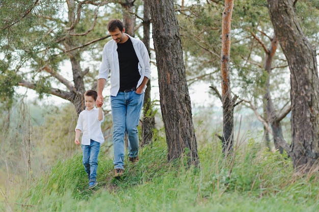 Padre feliz y niño caminando en el parque de verano