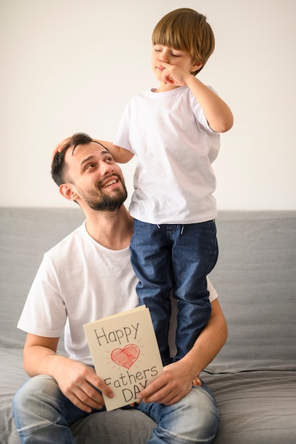 Foto padre feliz que sostiene la tarjeta de felicitación