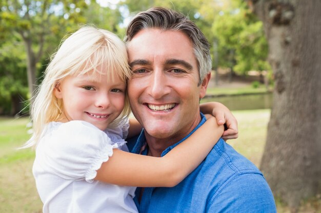 Padre feliz sonriendo a la cámara con su hija