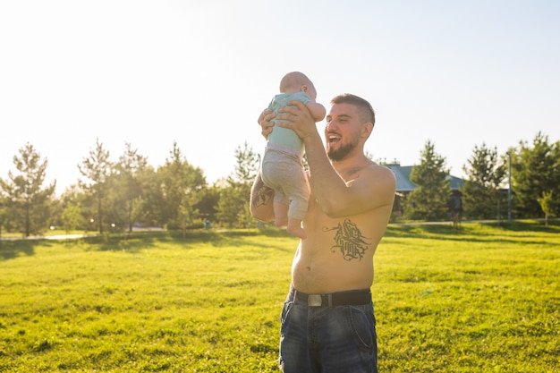 Padre feliz sosteniendo a su hijo, lanzando al bebé al aire. Concepto de familia feliz, día del padre e hijo.