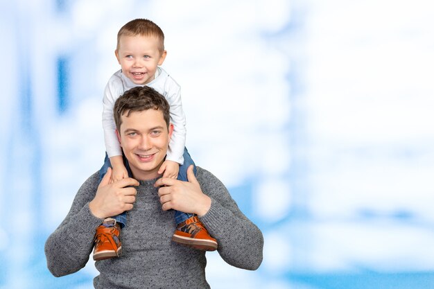 Padre feliz sosteniendo a su pequeño hijo