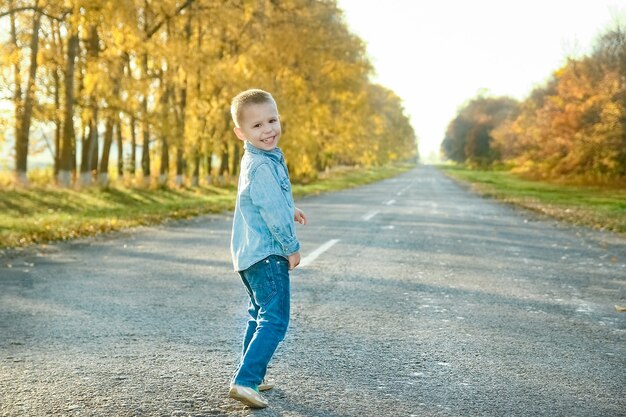 Un padre feliz con su hijo está caminando por la carretera en el parque en viajes por la naturaleza