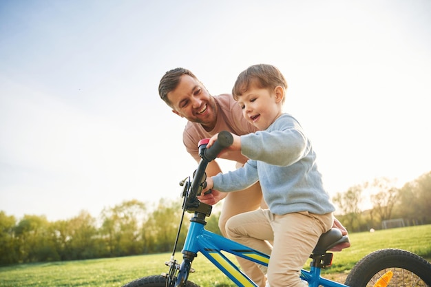 Un padre feliz y su hijo se están divirtiendo en el campo en verano.