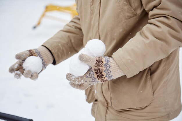 Padre hace bolas de nieve en el patio de la ciudad Pasar tiempo juntos Copiar espacio