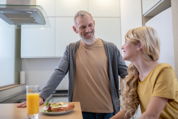 Un padre y una hija en la cocina desayunando.