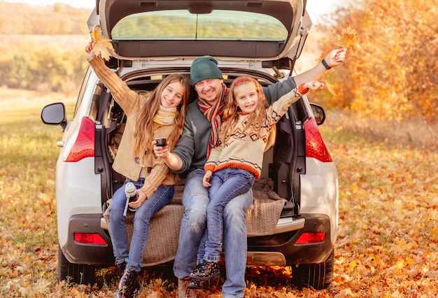 Padre con hijas en otoño