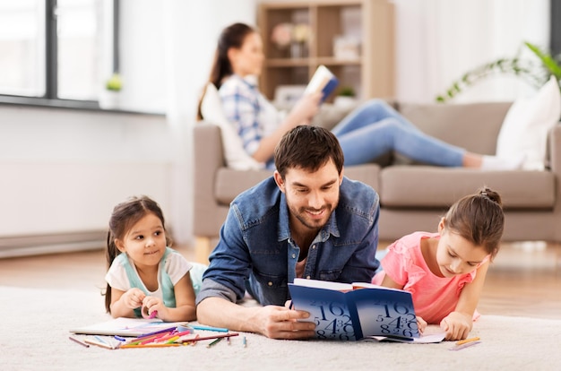 padre con hijas pequeñas dibujando en casa