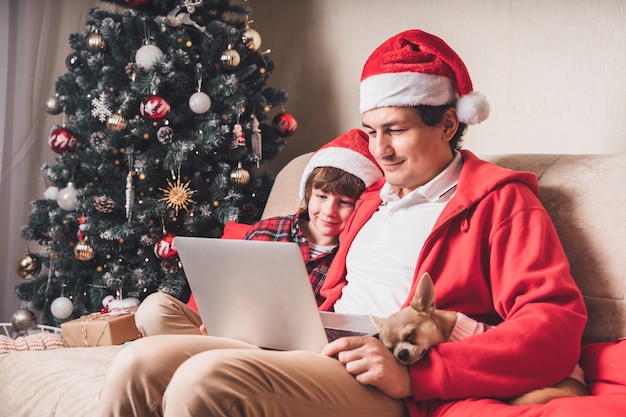 Padre con hijo en el día de Navidad con portátil