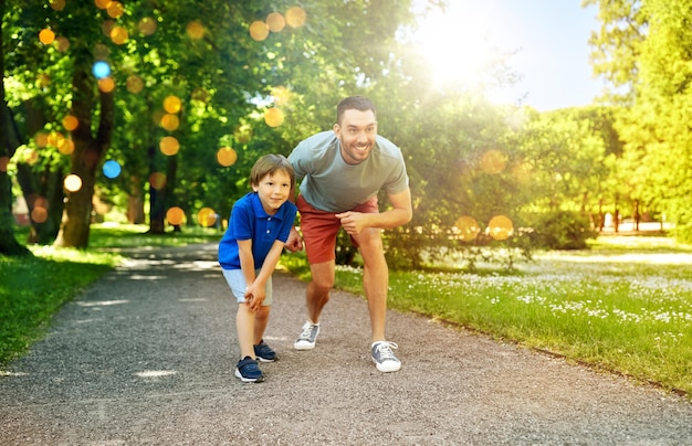 padre y hijo felices compiten en la carrera en el parque
