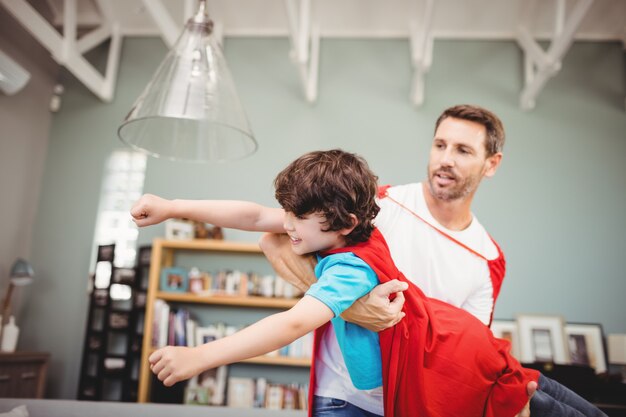 Padre con hijo vistiendo traje de superhéroe