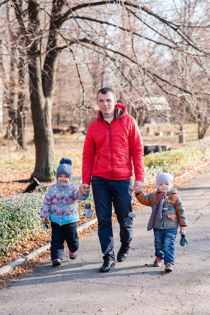 Padre con hijos caminando por el parque