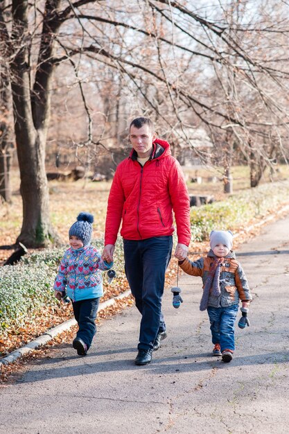 Padre con hijos caminando por el parque