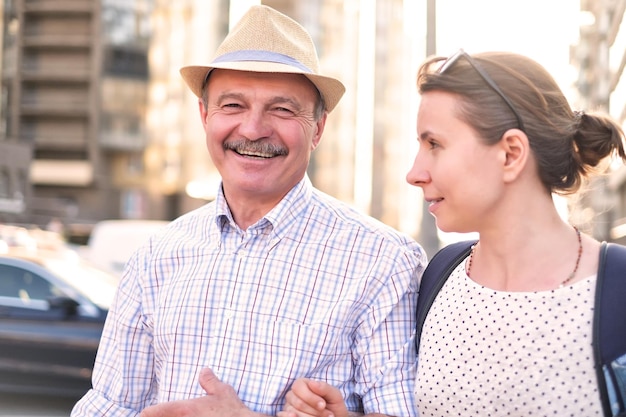 Padre hispano con sombrero de verano e hija caminando juntos al aire libre