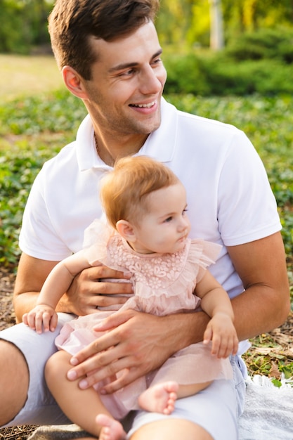 Padre joven feliz jugando con su pequeña hija