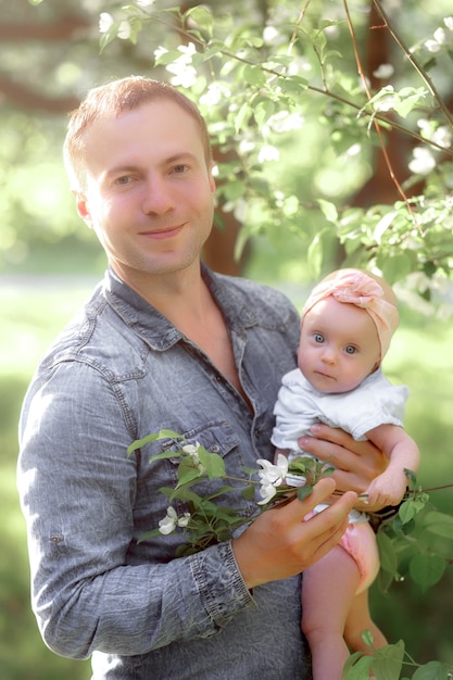 Padre joven con hija pequeña afuera en la naturaleza de primavera. Foto de alta calidad.