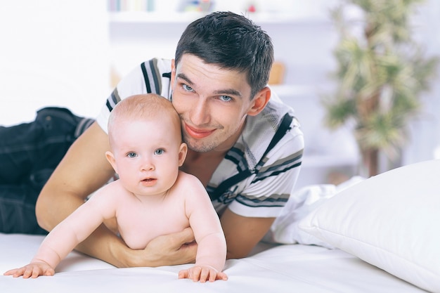 Foto padre joven, juego, con, bebé, en, sofá