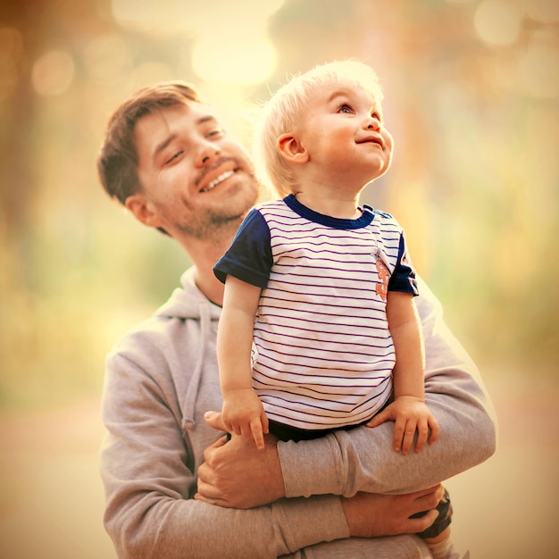 El padre joven sostiene a su hijo