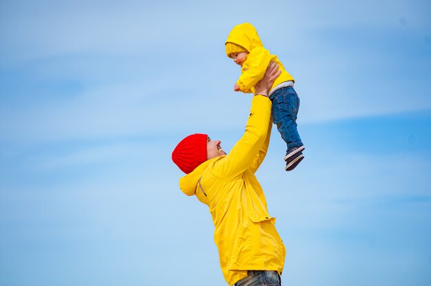 Padre joven con su hijo a la orilla del mar en invierno