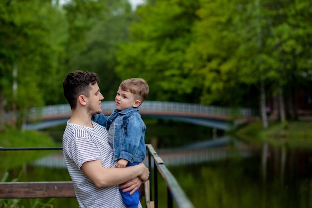 Padre joven y su hijo sonriente en el parque