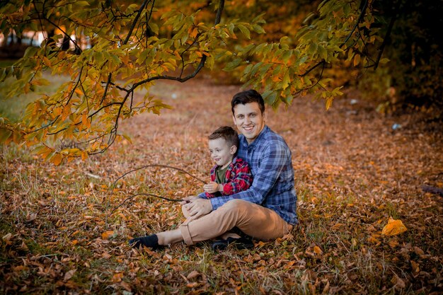 Padre joven y su pequeño hijo disfrutando al aire libre en un parque