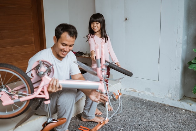 Padre joven, tenencia, bicicleta, marco, y, hija, proceso de llevar, ruedas